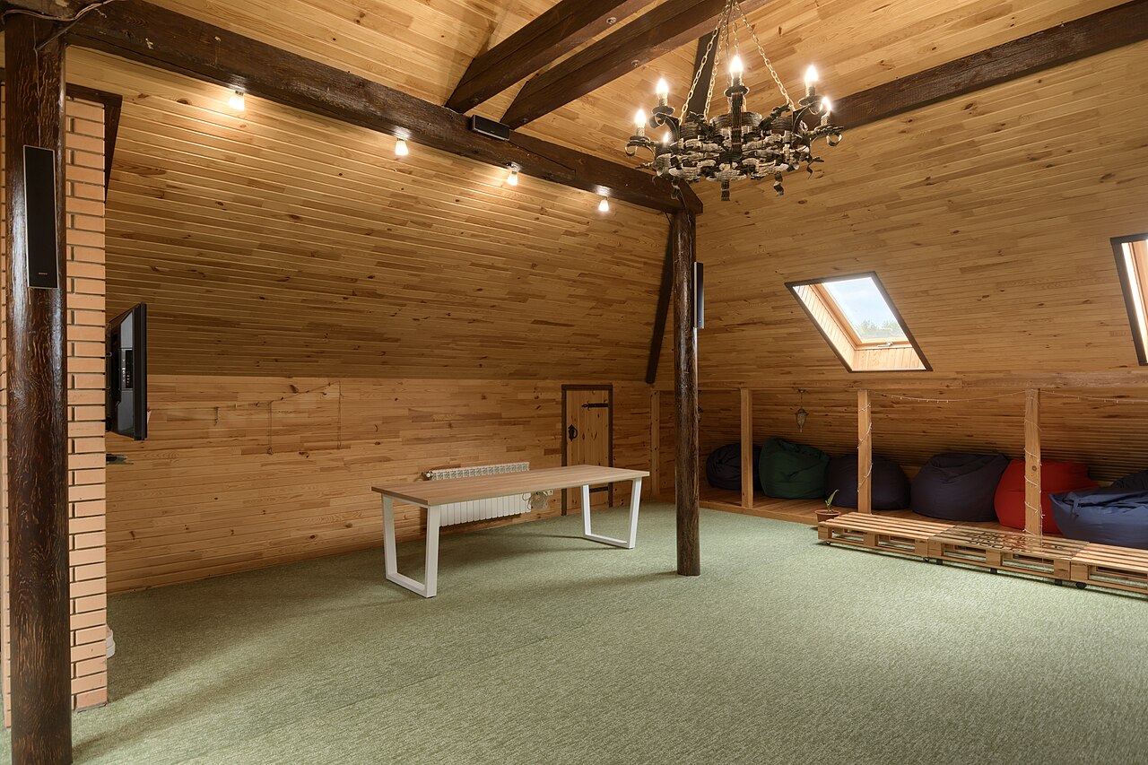 Intérieur de comble en pin, lucarne et planches au sol