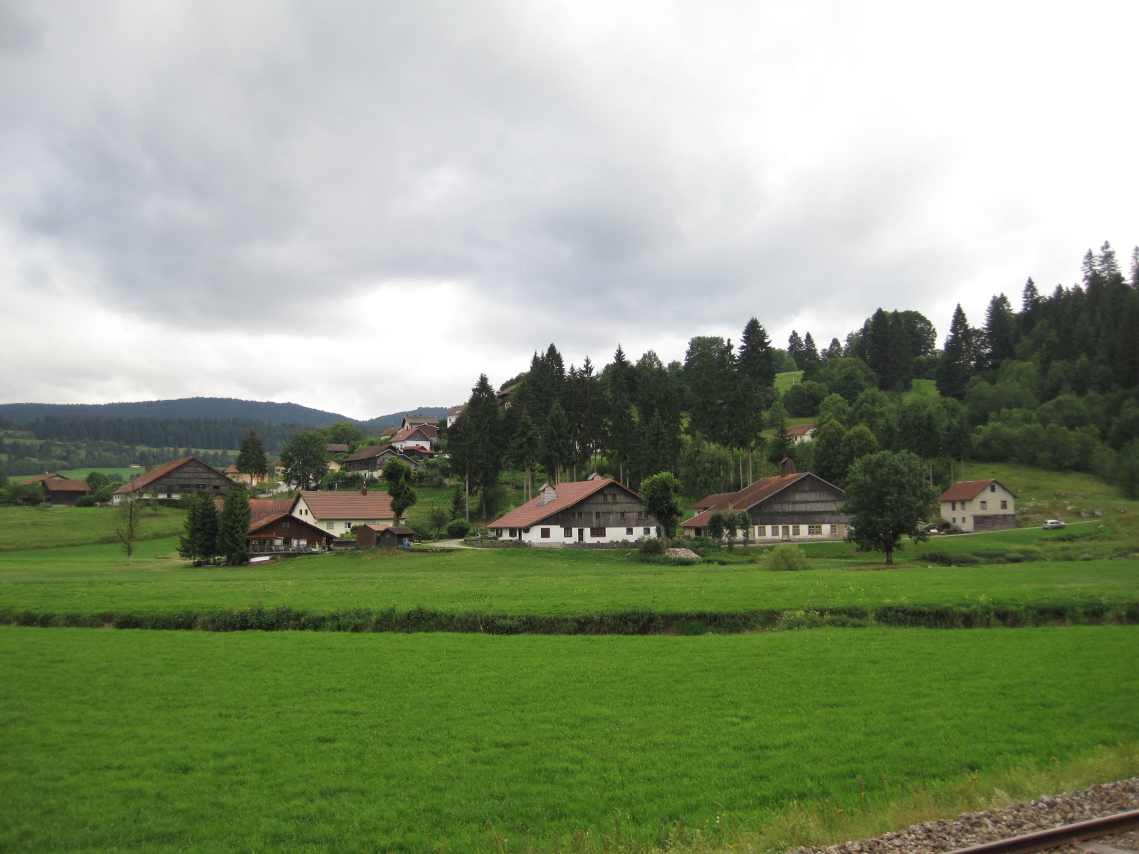 Hameau de fermes aux toits longs, plateaux boisés du Jura