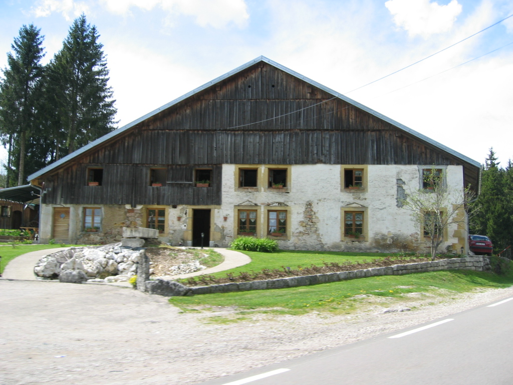 Ferme du Haut-Doubs, pignon bois et long bâtiment blanc